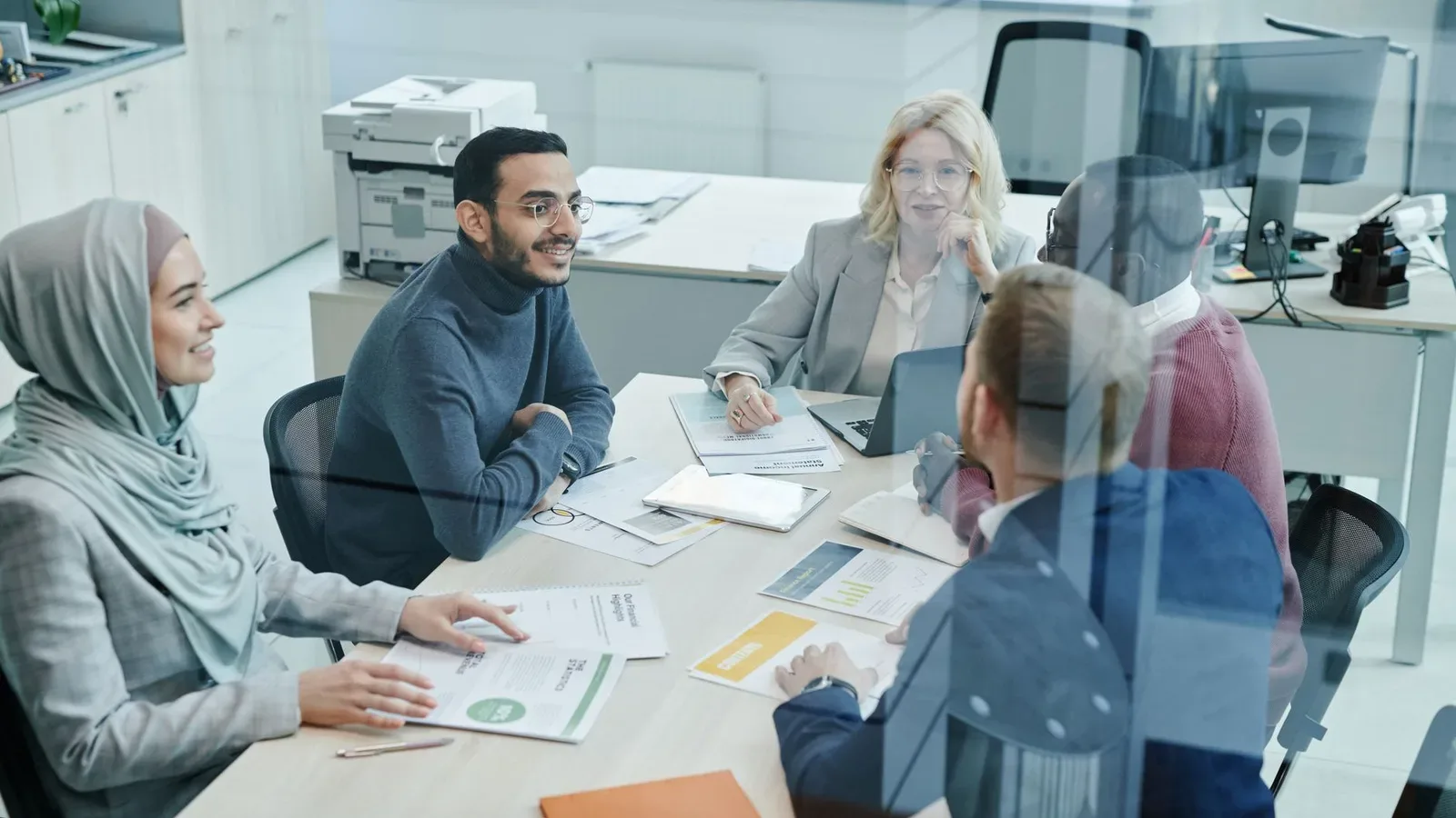 Professionals discussing a role around a table in a bright office